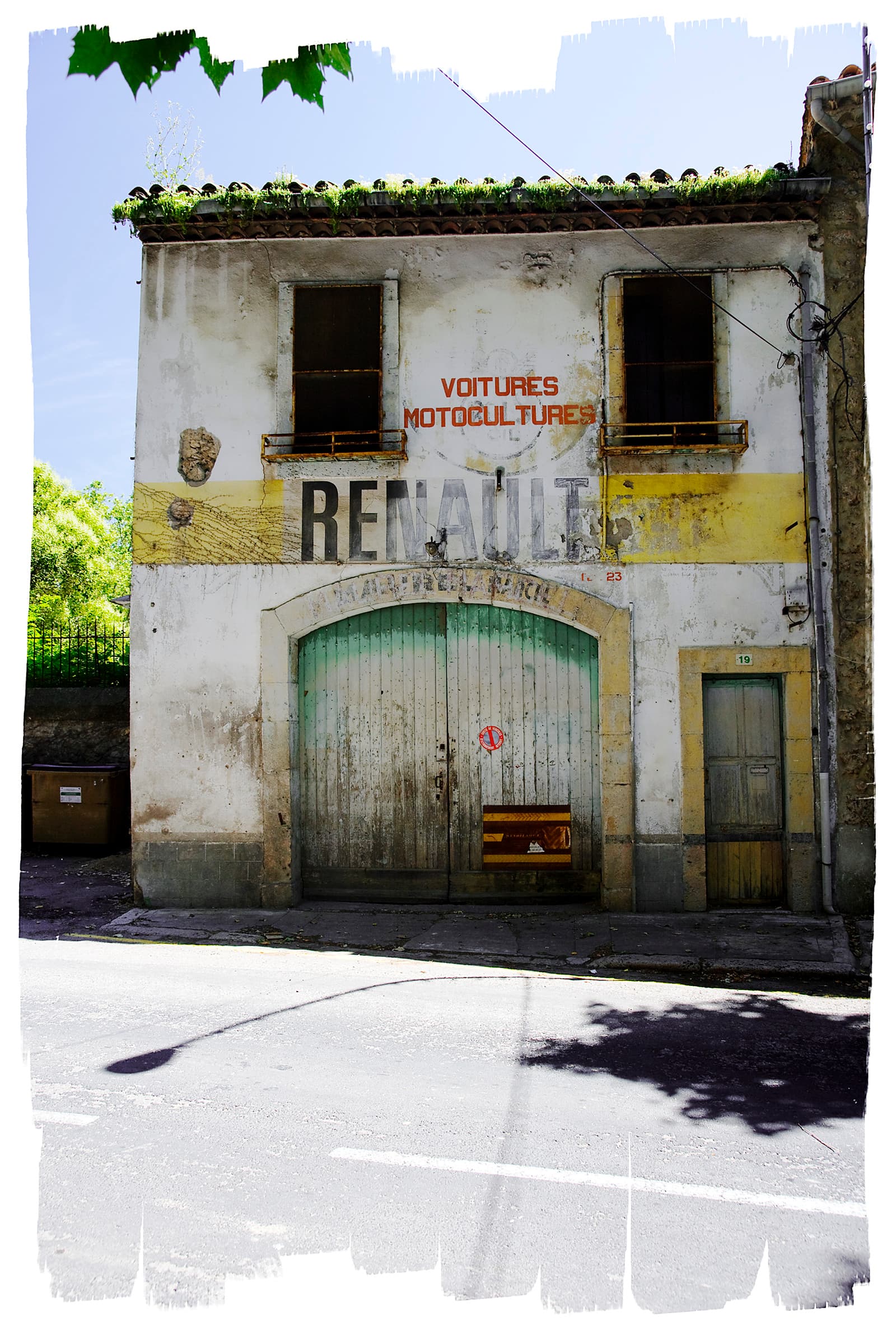 Faded Renault garage signage on a weathered Provençal building