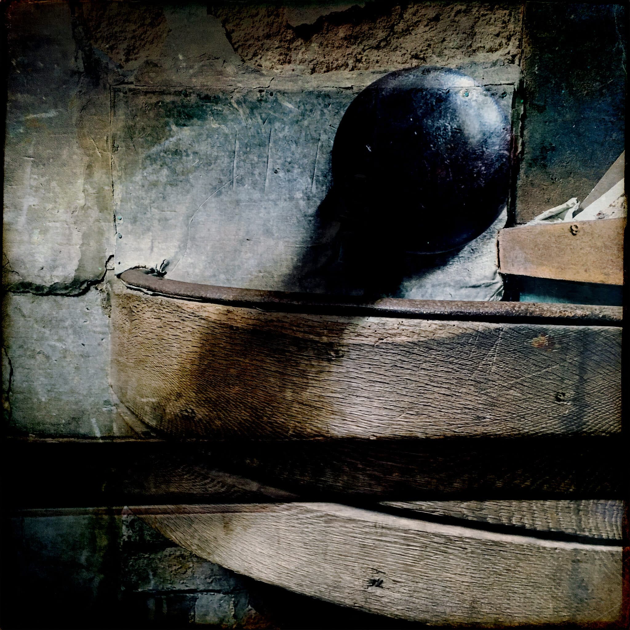 Dark round object in an old wooden trough, iPhone